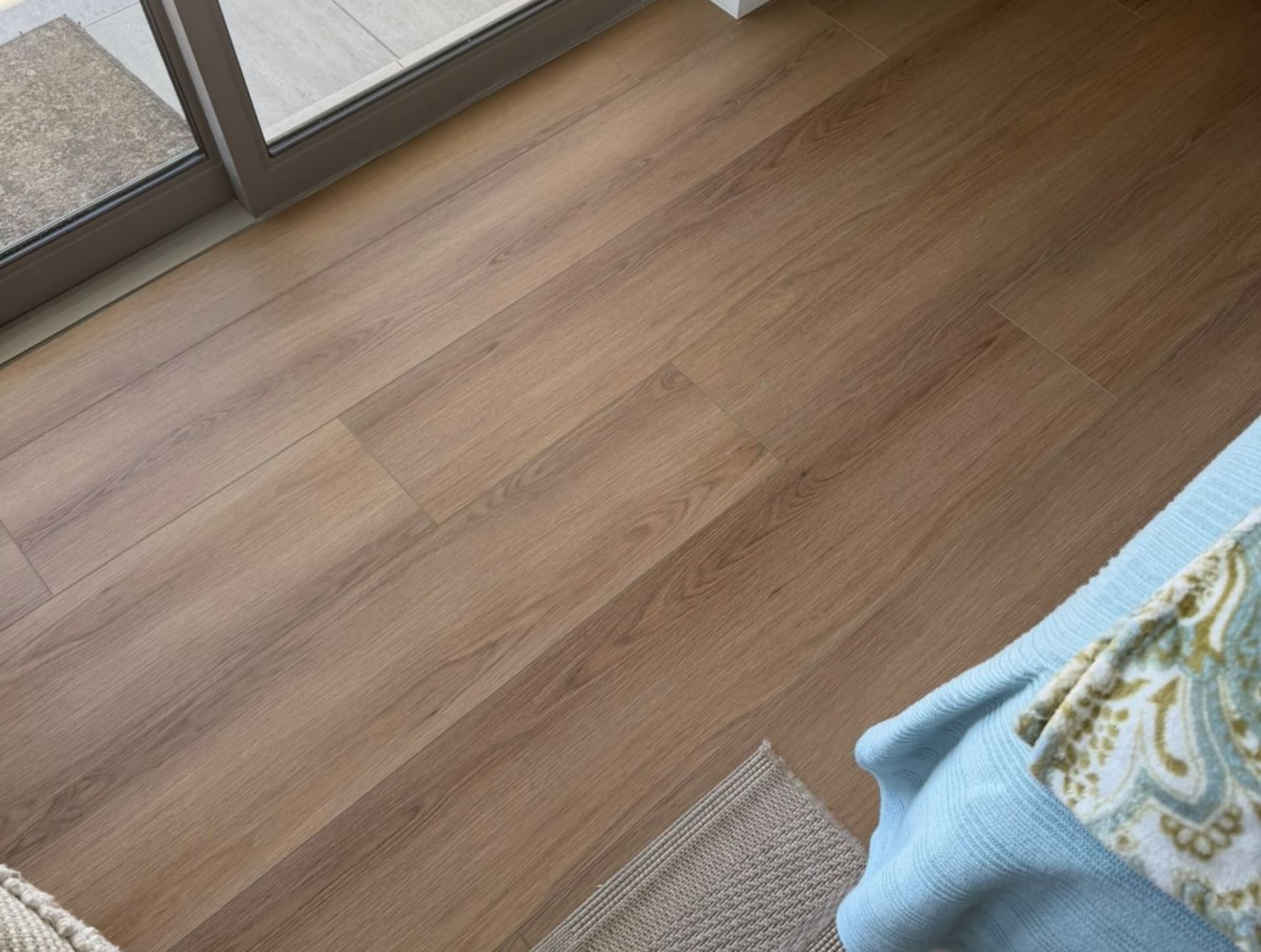 Close-up detail of the embossed surface texture and protective wear layer on a vinyl floor plank